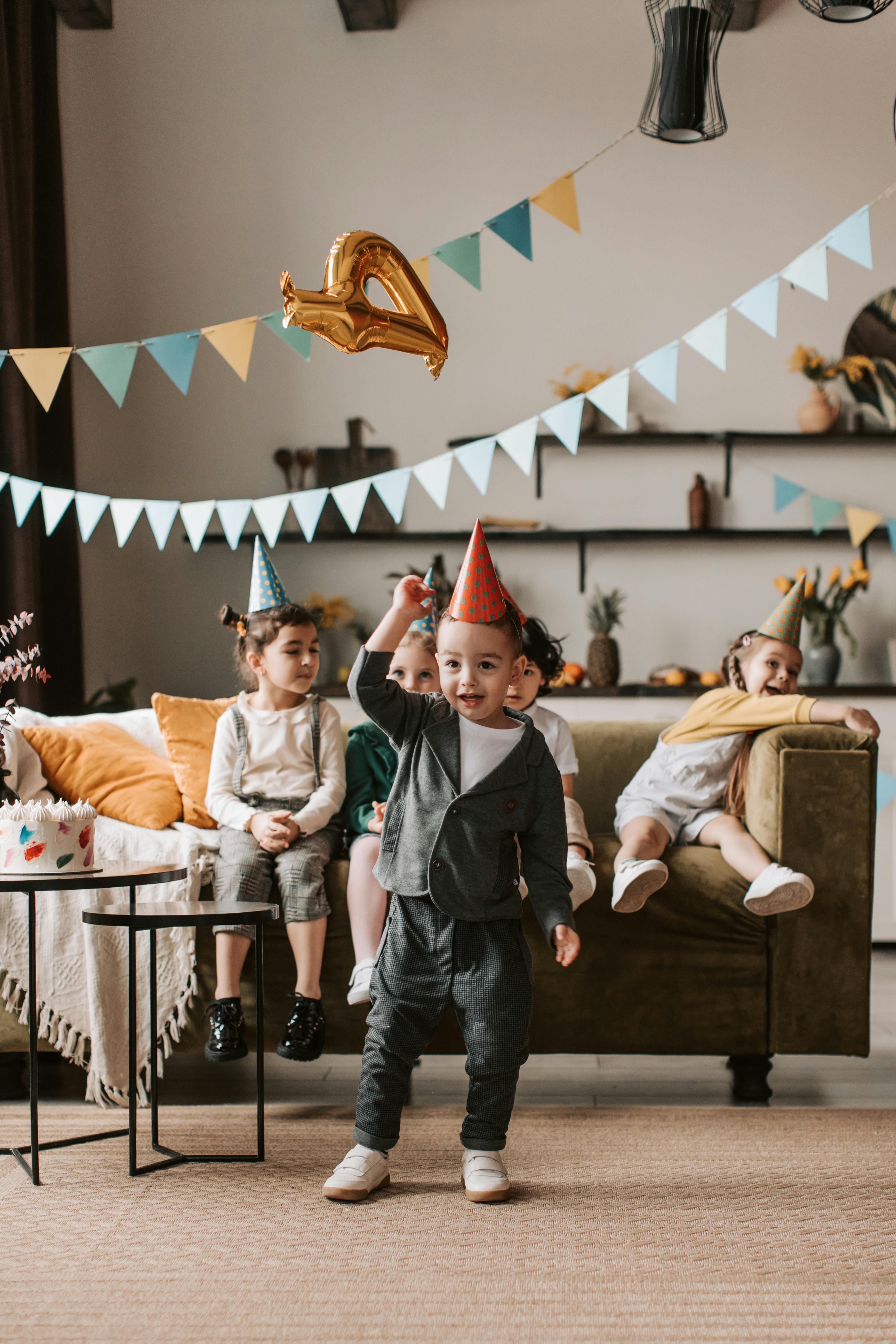 Kinder feiern Geburtstag mit Partyhüten und Girlanden